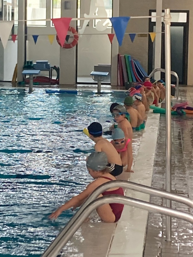 Niños y niñas en la piscina en una actividad de Firasport 2025