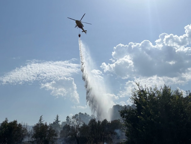 Helicóptero echando agua para apagar el incendio