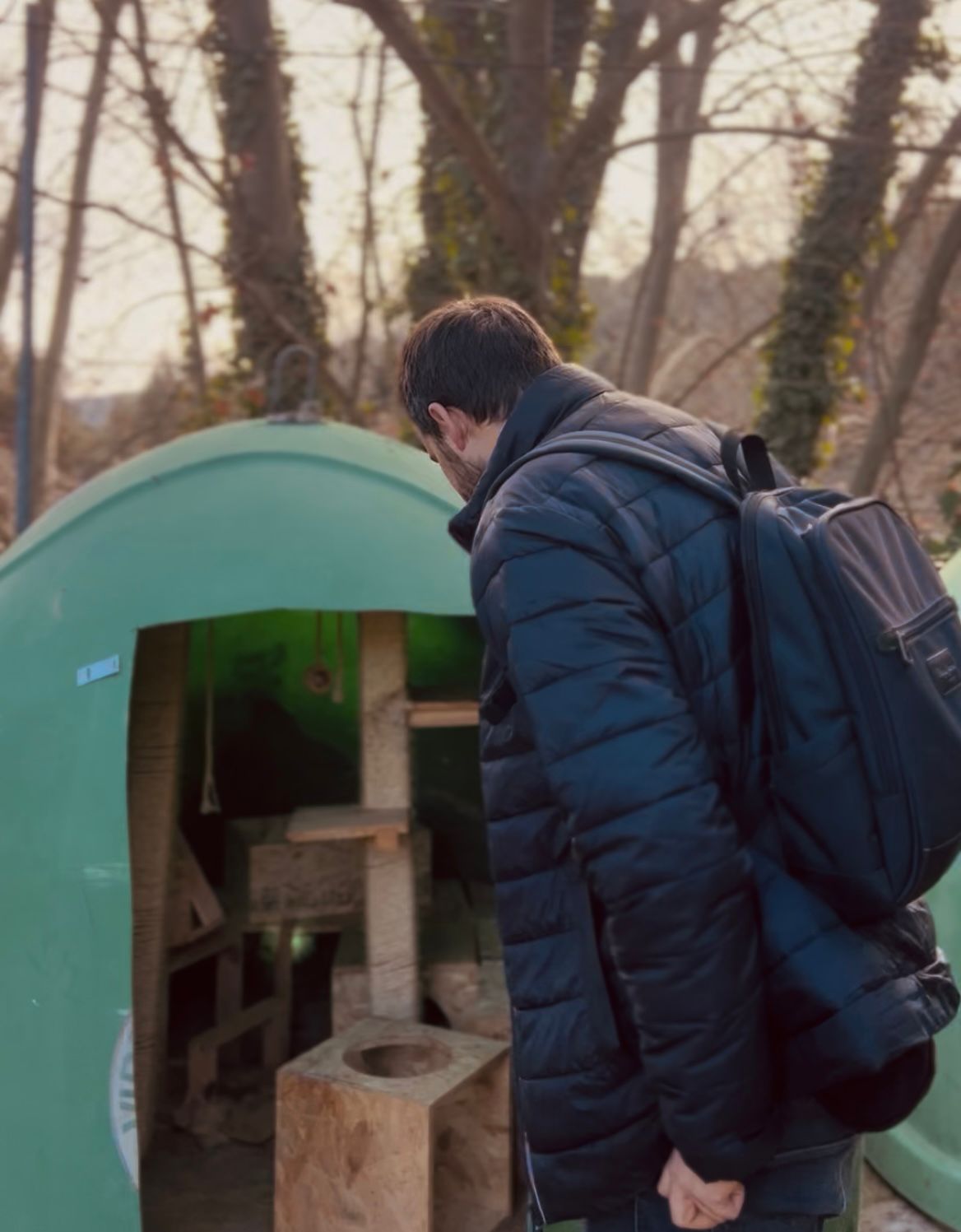 Persona observant l'antic iglú en l'interior del qual hi ha una torre de jocs i rascador de fusta per a gats