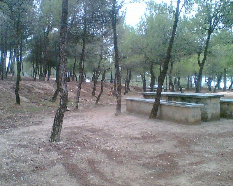Parte del área recreativa con mesa rectangular y banco de piedra