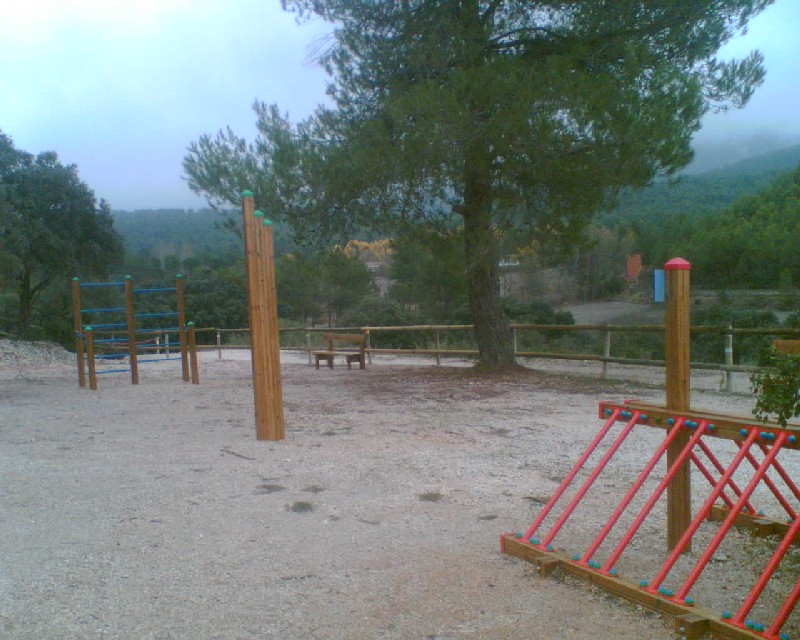 Zona con instalaciones de madera para hacer deporte, aparcabicis y banco