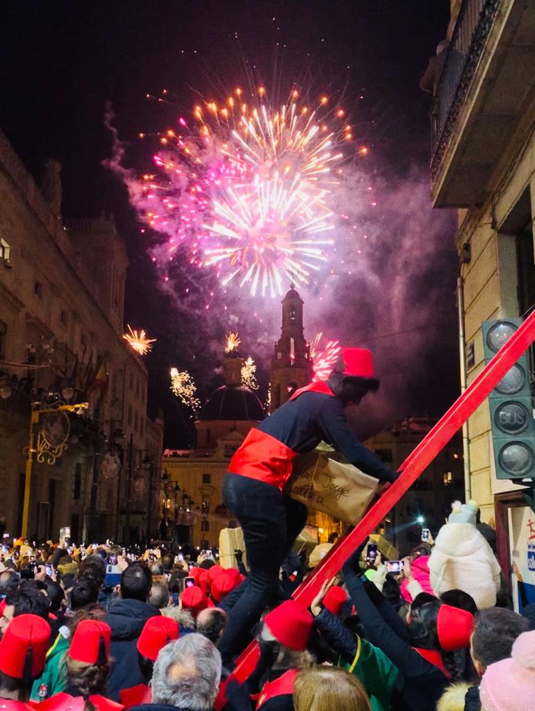 Foto paje subiendo escalera cargado con regalos