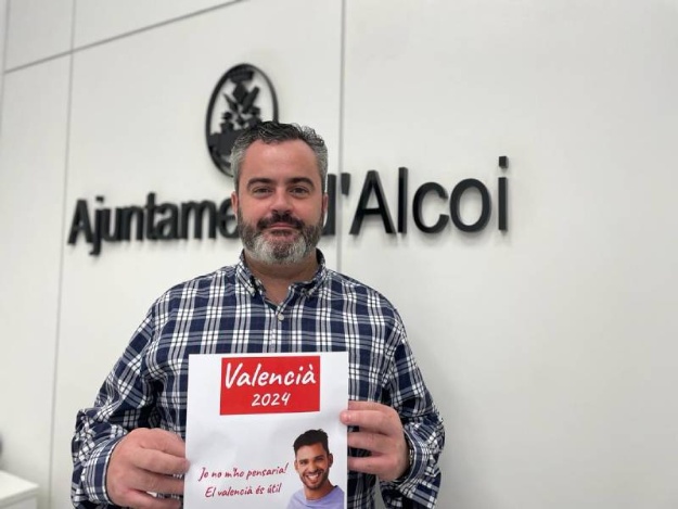 Concejal Raúl Llopis con cartel cursos de valenciano
