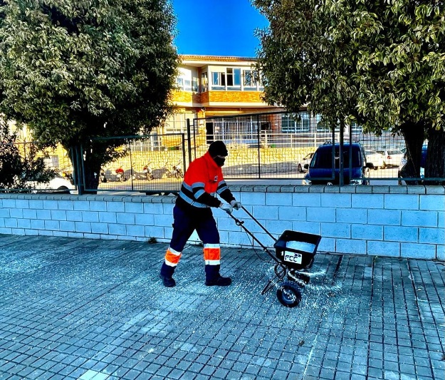 Trabajador tirando sal en la calle por las bajas temperaturas