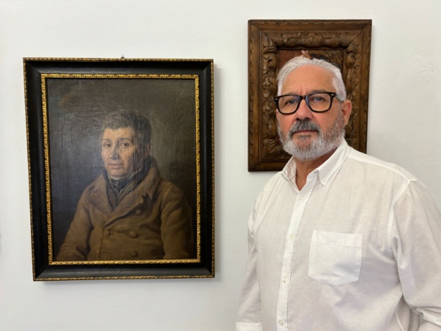 Ignació Trelis posando junto a la obra pictórica donada temporalmente al Ayuntamiento