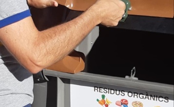 Imatge d'un ciutadà obrint un contenidor marró
