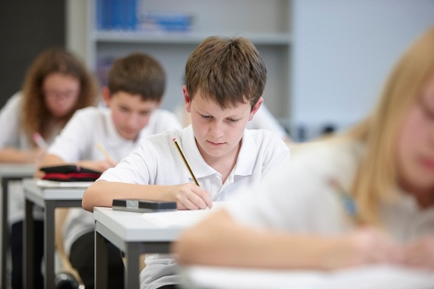 Foto de xiquets i xiquetes treballant en classe