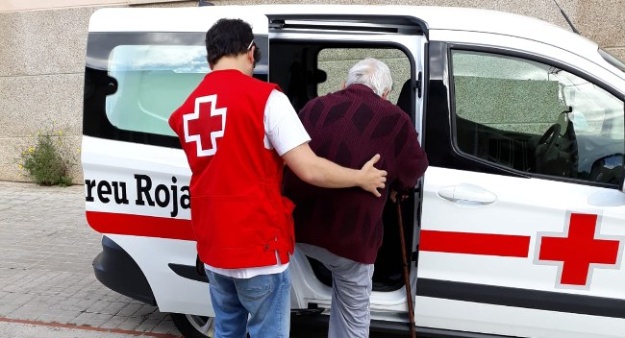 Un membre de la Creu Roja efectuant un trasllat en vehicle a un usuari