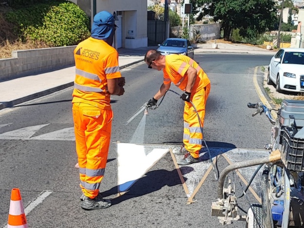 Dos operaris treballen en la senyalització de carreteres