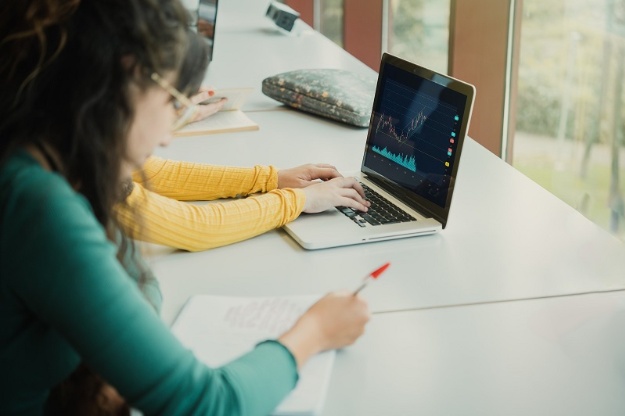 Estudiants treballant amb un portàtil