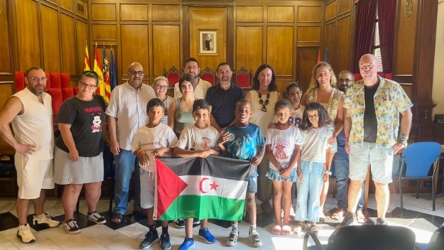 L'alcalde, el vicealcalde i la regidora d'Infància en la Sala de Plens amb els 5 menors i les famílies d'acollida amb la bandera sahrauí
