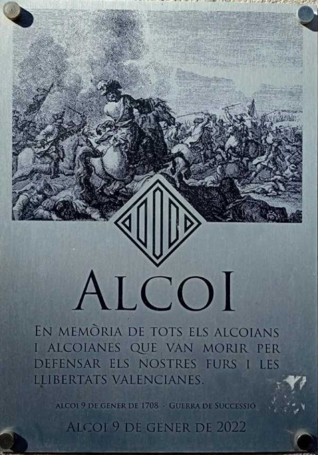 Placa conmemorativa: 'Alcoi. En memòria de tots els alcoians i alcoianes que van morir per defensar els nostres furs i les llibertats valencianes.'