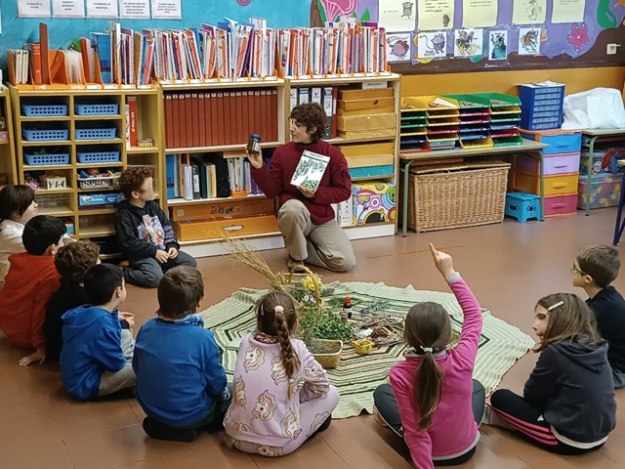 Educadora ambiental hablando de las plantas al alumnado en un aula