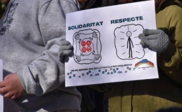 Imatge d'arxiu on es veuen les mans d'una xiqueta agafant un cartell que posa Solidaritat i Respecte