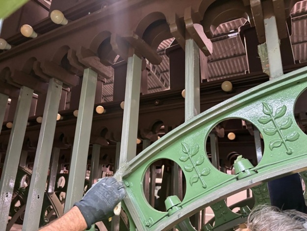 Operario repintando la enramada de Fiestas