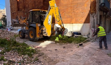 Operario y grúa limpiando el solar