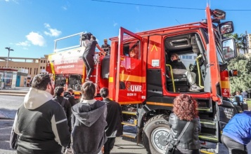 Un grup de persones observen un camió de l'UME