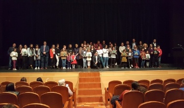 Clausura de la última Mostra con representantes de cada centro educativo en el escenario, el alcalde y el concejal de Educación