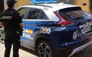 Cotxe i agent d'esquena de la Policia Nacional