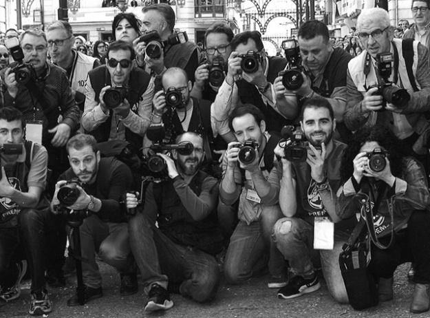 Fotògrafs amuntonats en Festes usant càmeres de foto i vídeo cobrint un esdeveniment
