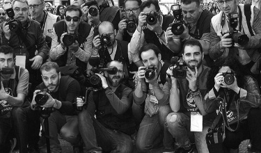 Fotógrafos amontonados en Fiestas usando cámaras de foto y video cubriendo un evento
