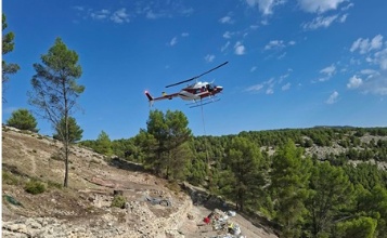 Helicòpter descarregant materials en el poblat del Castellar