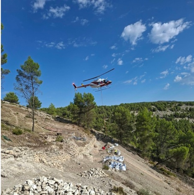Helicòpter descarregant materials en el poblat del Castellar