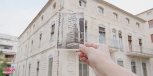 captura de pantalla del vídeo sobre el modernismo en el que se ve una mano sosteniendo una foto antigua con la Casa Escaló de fondo